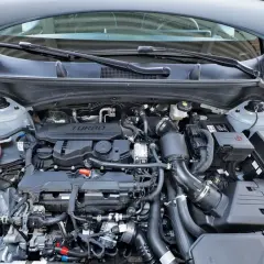 Silnik 1.6 GDI Turbo w samochodzie z otwartą maską. Widoczne przewody, turbosprężarka i inne elementy jednostki napędowej.