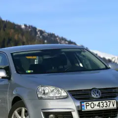 Srebrna Jetta MK5 na tle ośnieżonych gór i lasu.
