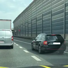Kork na autostradzie, samochody stoją w rzędzie. Kierowcy czekają na możliwość jazdy na suwak, by płynnie włączyć się do ruchu.