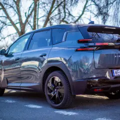 Ciemnoszary Citroen C5 Aircross, nowoczesny citroen suv, zaparkowany na tle drzew.