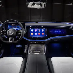 Wnętrze e53 AMG z podświetlanymi na niebiesko detalami, dużymi ekranami i sportową kierownicą.