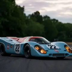 Legenda wyścigowa Porsche 917 w barwach Gulf, z numerem 22, gotowa do startu na torze.