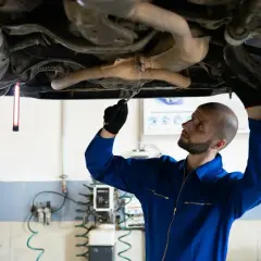Mechanik sprawdza podwozie Audi, szukając przyczyny błędu DTC P0420.