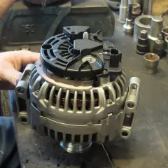 Mechanik pracuje nad regeneracją alternatora. Sprawdź, jaka jest regeneracja alternatora cena i przywróć sprawność pojazdu.