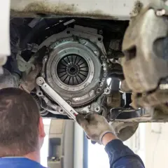Mechanik dokonuje wymiany sprzęgła w samochodzie, używając klucza dynamometrycznego do precyzyjnego dokręcenia śrub.