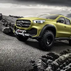 Żółty Mercedes pickup z wyciągarką gotowy na terenową przygodę po kamienistym pustkowiu.