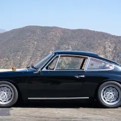 Klasyczny czarny Porsche 912 z lat 60. na tle górskich krajobrazów.