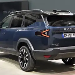 Ciemnoniebieski Dacia Bigster z czarnymi relingami dachowymi i efektownymi światłami LED.