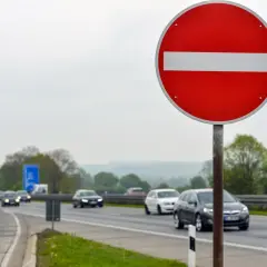 Znak "zakaz wjazdu" ostrzega przed niebezpieczną jazdą pod prąd. Ryzyko mandatu i wypadku jest wysokie.
