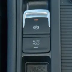 Przycisk "AUTO HOLD" w samochodzie, obok hamulca ręcznego.