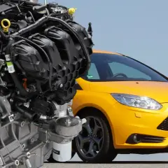 Silnik 2.0 Ecoboost obok żółtego Forda Focus ST. Potężna jednostka napędowa, serce sportowego samochodu.