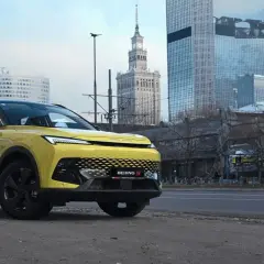 Żółty BEIJING 5 na tle miejskiej panoramy z wieżowcami. Nowoczesny design i miejski krajobraz.