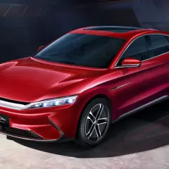 Błyszczący, czerwony sedan BYD Han prezentuje nowoczesny design z eleganckimi liniami i futurystycznymi światłami.