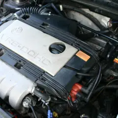 Silnik VR6-DOHC z widocznym filtrem powietrza i zbiorniczkiem płynu chłodniczego.