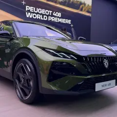 Nowy Peugeot 408 w kolorze zielonym prezentuje się na premierze światowej. Obok stoi niebieski egzemplarz.
