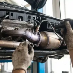 Mechanik sprawdza układ wydechowy Toyoty, szukając przyczyny błędu DTC P0420.