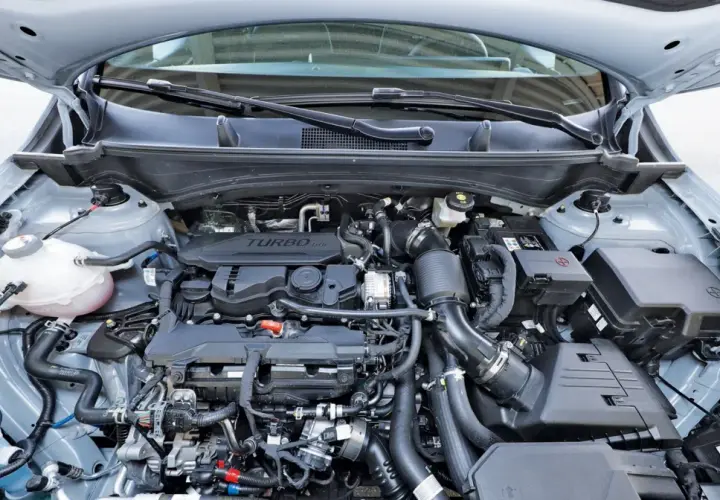 Silnik 1.6 GDI Turbo w samochodzie z otwartą maską. Widoczne przewody, turbosprężarka i inne elementy jednostki napędowej.