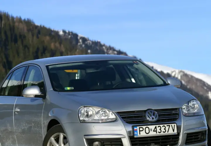 Srebrna Jetta MK5 na tle ośnieżonych gór i lasu.