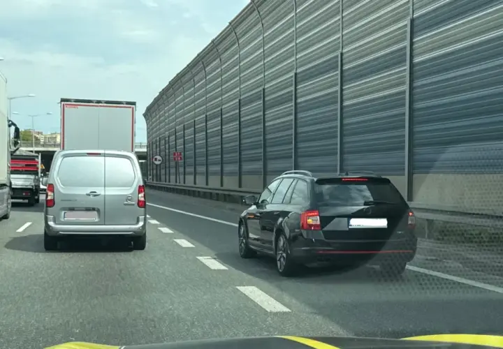 Kork na autostradzie, samochody stoją w rzędzie. Kierowcy czekają na możliwość jazdy na suwak, by płynnie włączyć się do ruchu.