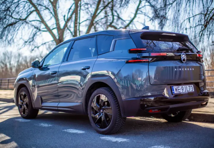 Ciemnoszary Citroen C5 Aircross, nowoczesny citroen suv, zaparkowany na tle drzew.