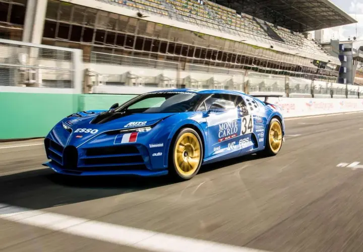 Niebieski Bugatti Centodieci z numerem 34 i złotymi felgami pędzi po torze wyścigowym.