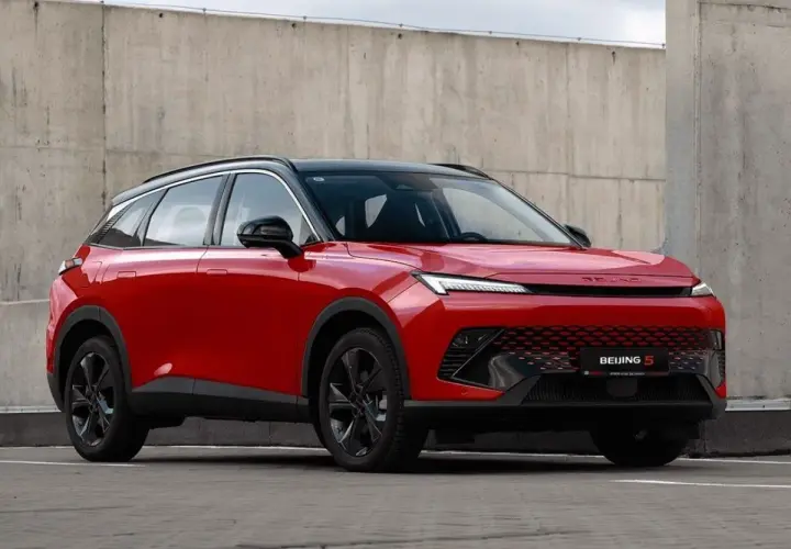 Czerwony BAIC 5, SUV o futurystycznym designie, prezentuje swoje pięć wymiarów na tle betonowej ściany.