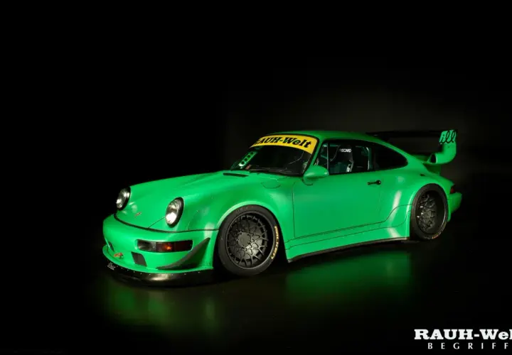 Jaskrawozielone Porsche RWB z szerokimi błotnikami i charakterystycznym skrzydłem, gotowe do wyścigu.