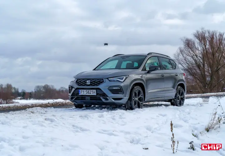Szary Seat Ateca FR na śniegu, gotowy na zimowe wyzwania.