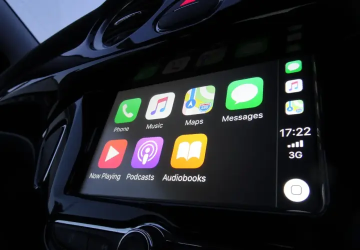 Ekran samochodu z ikonami: Telefon, Muzyka, Mapy, Wiadomości, Odtwarzanie, Podcasty, Audiobooki. To jest właśnie co to jest CarPlay.