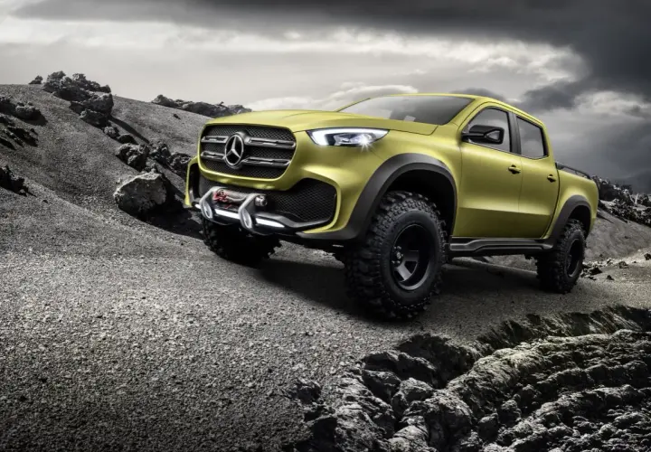 Żółty Mercedes pickup z wyciągarką gotowy na terenową przygodę po kamienistym pustkowiu.
