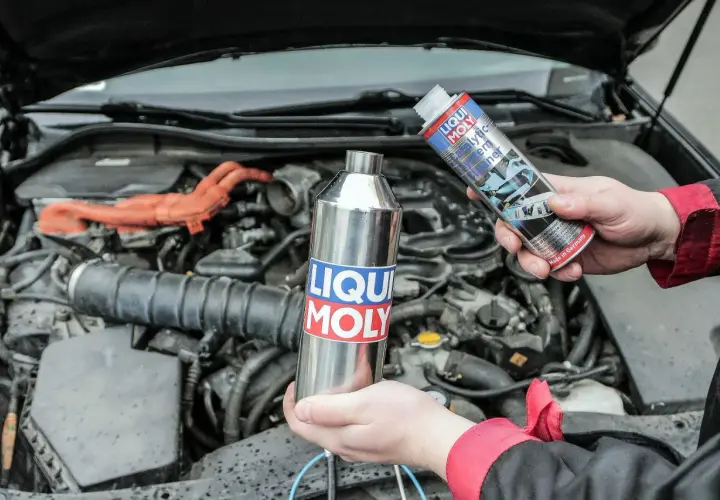 Ręce trzymają preparaty Liqui Moly do czyszczenia układu paliwowego, by zapobiec objawom zapchanego katalizatora.