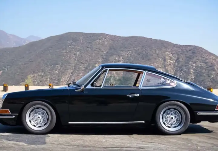 Klasyczny czarny Porsche 912 z lat 60. na tle górskich krajobrazów.