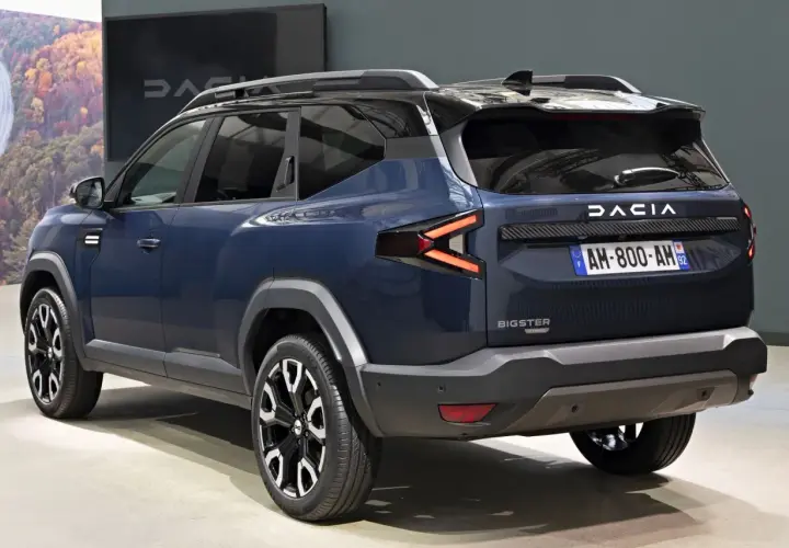 Ciemnoniebieski Dacia Bigster z czarnymi relingami dachowymi i efektownymi światłami LED.