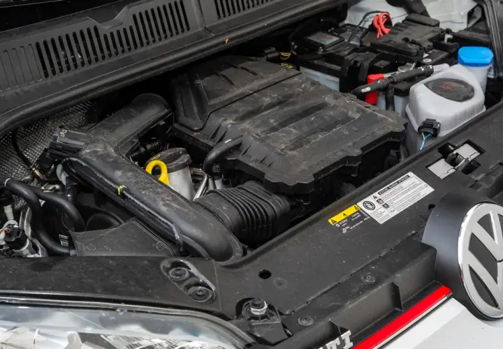 Silnik 1.0 TSI w samochodzie Volkswagen. Widoczny jest blok silnika, akumulator i płyny eksploatacyjne.