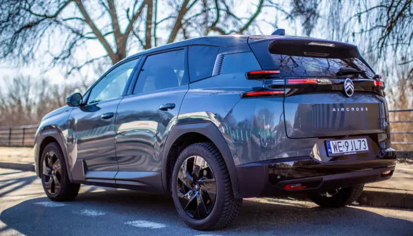 Ciemnoszary Citroen C5 Aircross, nowoczesny citroen suv, zaparkowany na tle drzew.