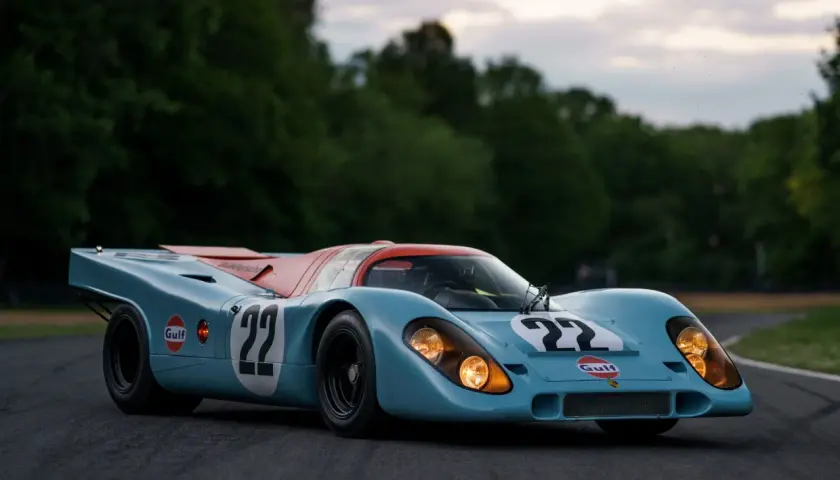 Legenda wyścigowa Porsche 917 w barwach Gulf, z numerem 22, gotowa do startu na torze.