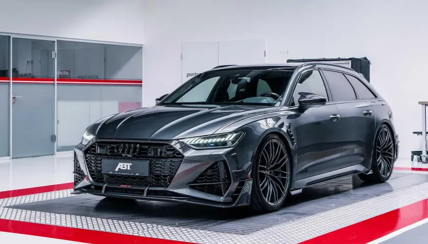 Mroczny Audi RS6 Avant, tuningowany przez ABT, prezentuje agresywny design z karbonowymi elementami i masywnymi felgami.
