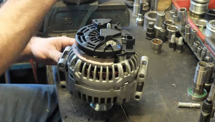 Mechanik pracuje nad regeneracją alternatora. Sprawdź, jaka jest regeneracja alternatora cena i przywróć sprawność pojazdu.