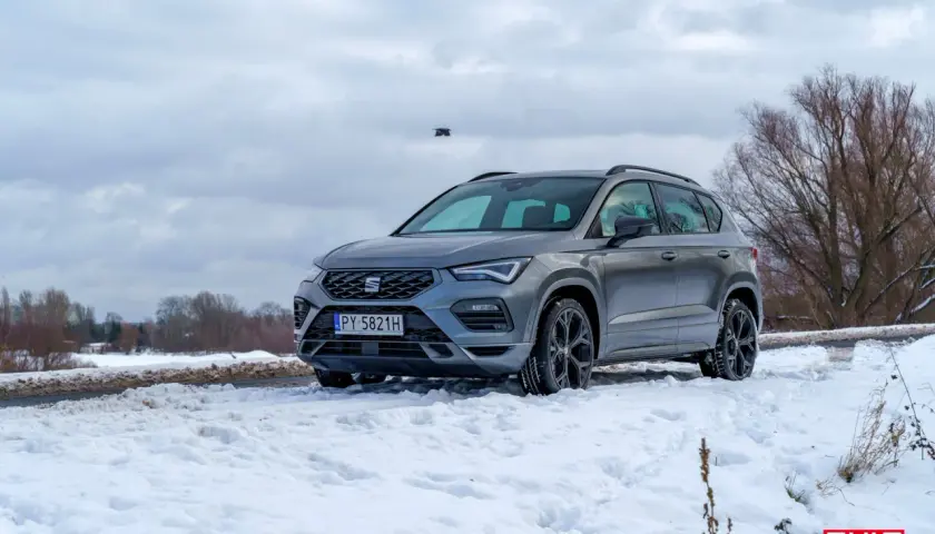Szary Seat Ateca FR na śniegu, gotowy na zimowe wyzwania.
