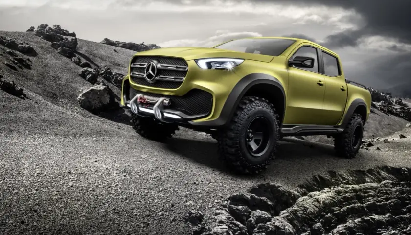 Żółty Mercedes pickup z wyciągarką gotowy na terenową przygodę po kamienistym pustkowiu.