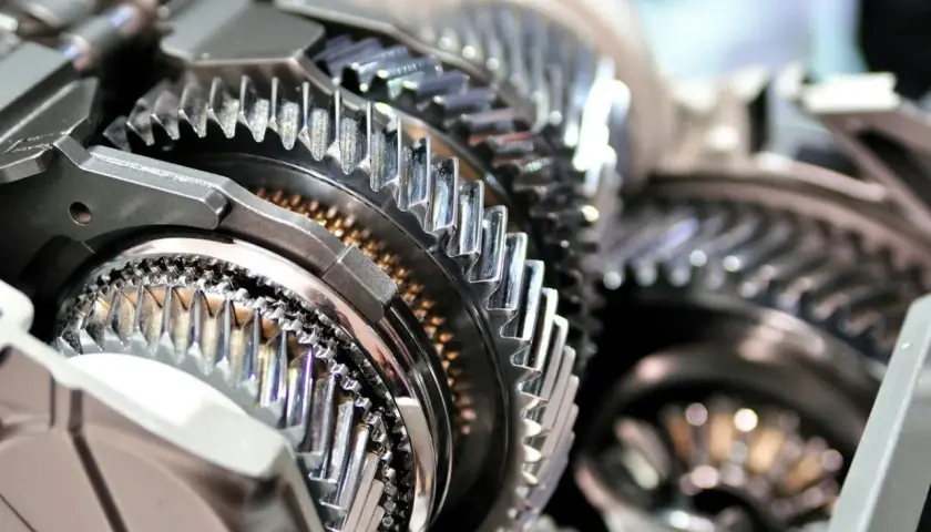 Metalowe koła zębate w przekładni. Precyzyjny reduktor gotowy do pracy, błyszczące zęby tworzą skomplikowany mechanizm.