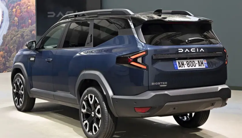 Ciemnoniebieski Dacia Bigster z czarnymi relingami dachowymi i efektownymi światłami LED.