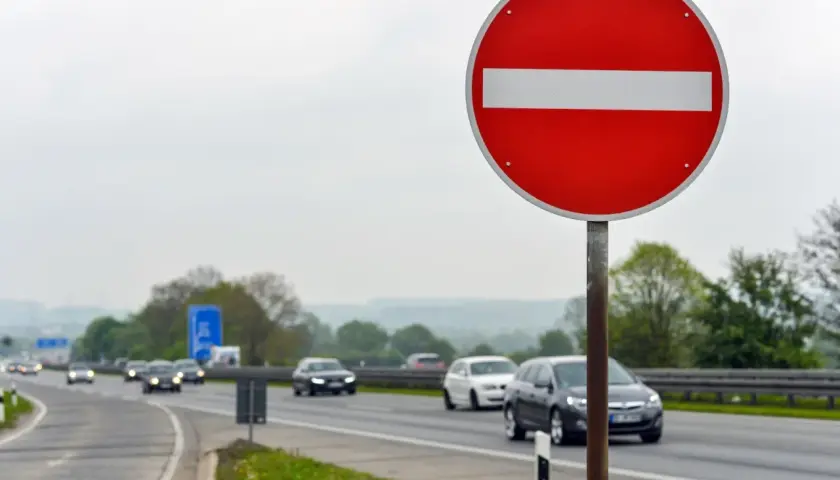 Znak "zakaz wjazdu" ostrzega przed niebezpieczną jazdą pod prąd. Ryzyko mandatu i wypadku jest wysokie.
