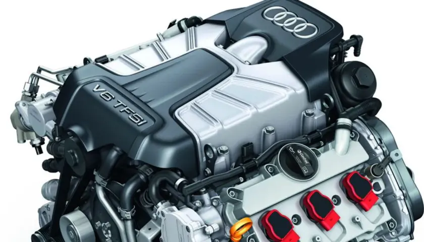 Silnik V6 TFSI Audi z widocznymi cewkami zapłonowymi i logo marki.