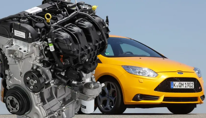 Silnik 2.0 Ecoboost obok żółtego Forda Focus ST. Potężna jednostka napędowa, serce sportowego samochodu.