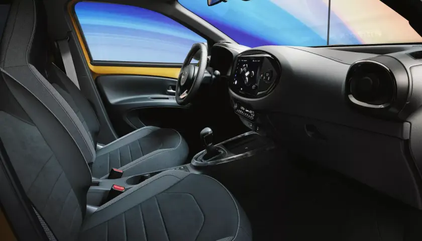 Wnętrze samochodu z nowoczesnymi fotelami i ekranem dotykowym. System keyless go ułatwia wsiadanie i ruszanie.