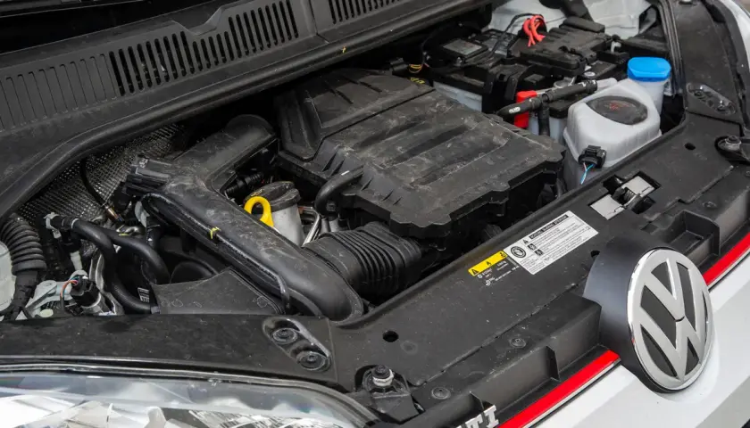 Silnik 1.0 TSI w samochodzie Volkswagen. Widoczny jest blok silnika, akumulator i płyny eksploatacyjne.