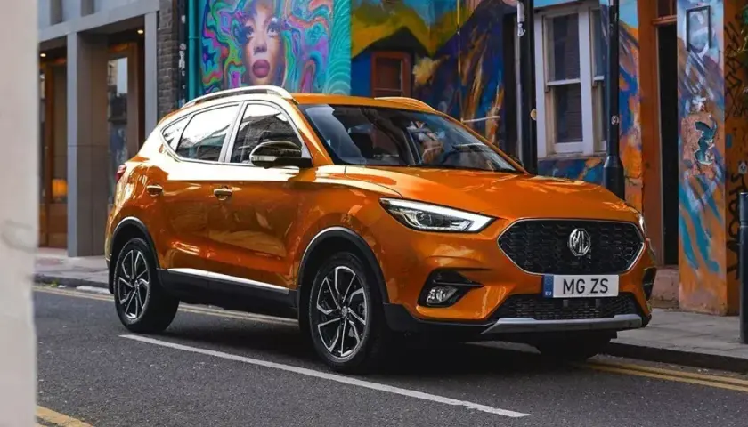Pomarańczowy MG ZS Classic na tle kolorowego muralu.