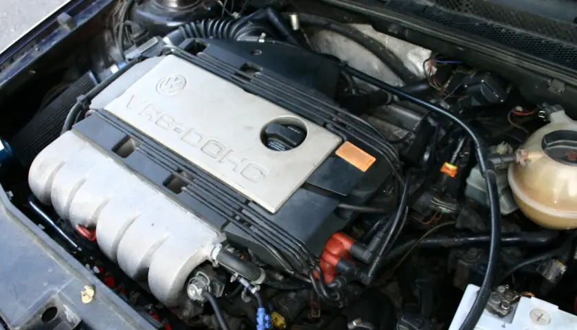 Silnik VR6-DOHC z widocznym filtrem powietrza i zbiorniczkiem płynu chłodniczego.