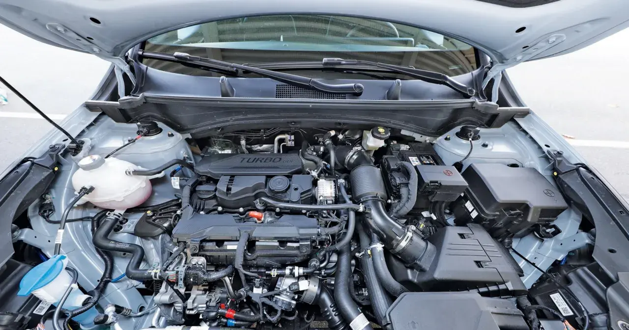 Silnik 1.6 GDI Turbo w samochodzie z otwartą maską. Widoczne przewody, turbosprężarka i inne elementy jednostki napędowej.